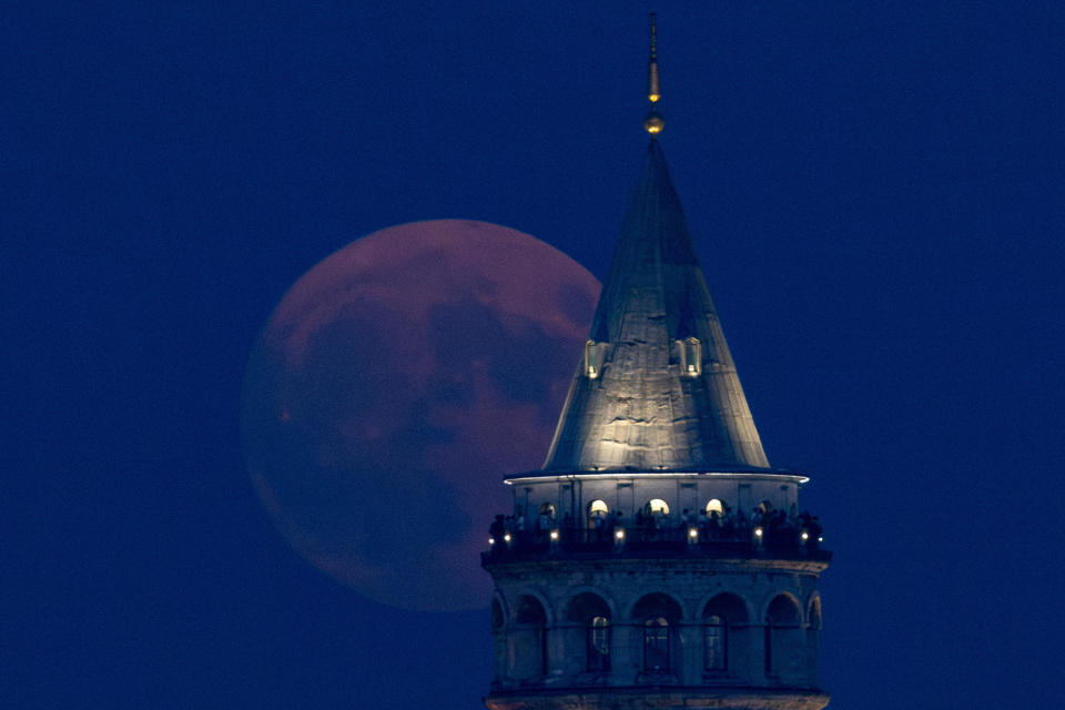 Tourists visit Istanbul's famous Galata Tower as a rare super blue moon rises behind on Aug. 30, 2023 in Istanbul, Turkey. / Credit: Chris McGrath / Getty Images