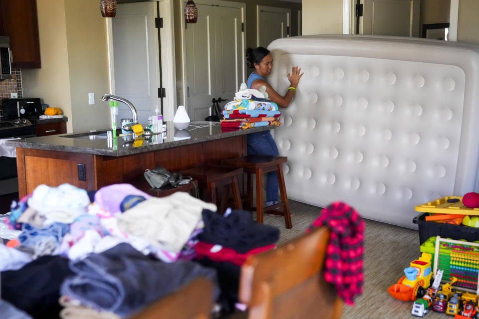 Erika Erickson, whose grandmother Louise Abihai died in the August wildfire, moves an air mattress in her family's room at the Honua Kai Resort & Spa, where they currently live after being displaced, Friday, Dec. 8, 2023, in the Kaanapali area of Lahaina, Hawaii. While the family has been told they can stay until early next year, "the tricky part is, you still don't know if you might get a call (to move)." The deadliest U.S. wildfire in more than a century took the lives of at least 100 people and destroyed most of the historic town of Lahaina on the Hawaiian island of Maui. (AP Photo/Lindsey Wasson)