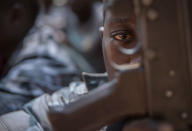 <p>A newly released child soldier looks through a rifle trigger guard during a release ceremony for child soldiers in Yambio, South Sudan on Feb. 7, 2018. (Photo: Stefanie Glinski/AFP/Getty Images) </p>