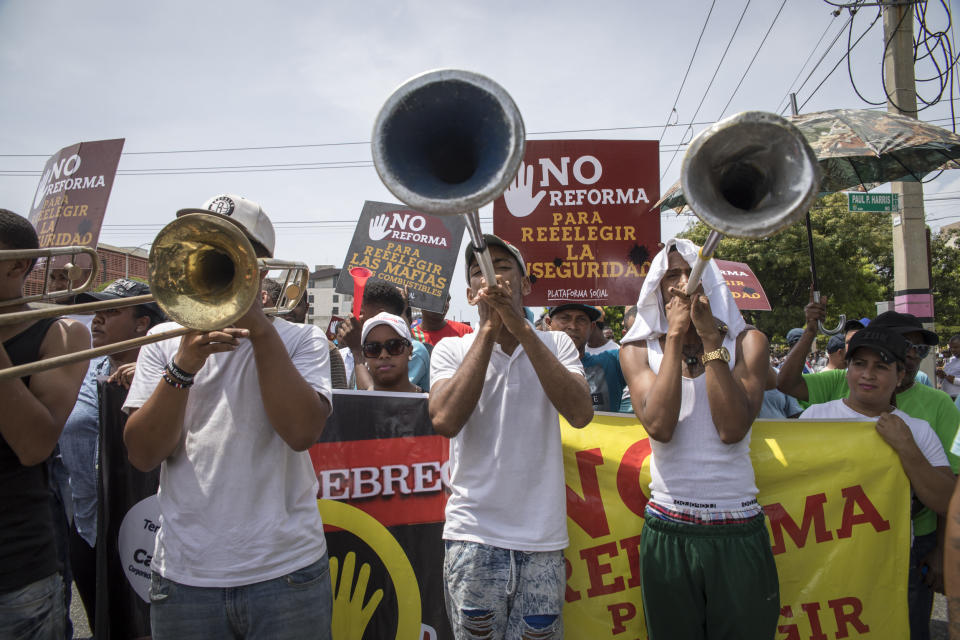 People gather outside the National Congress during a protest against a Constitutional reform that would allow President Danilo Medina a third term in office, in front of the National Congress in Santo Domingo, Dominican Republic, Wednesday, June 26, 2019. The proposal has provoked protests from Dominicans who call it backsliding on a young democracy that emerged from decades of brutal dictatorship. (AP Photo/Tatiana Fernandez)