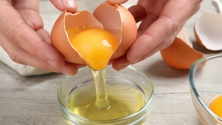 Hands cracking open an egg