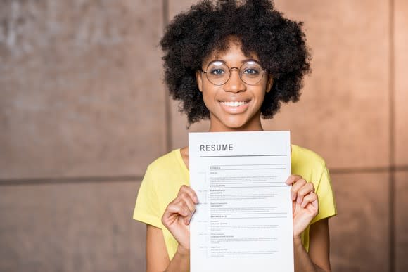 Woman holding up a resume.