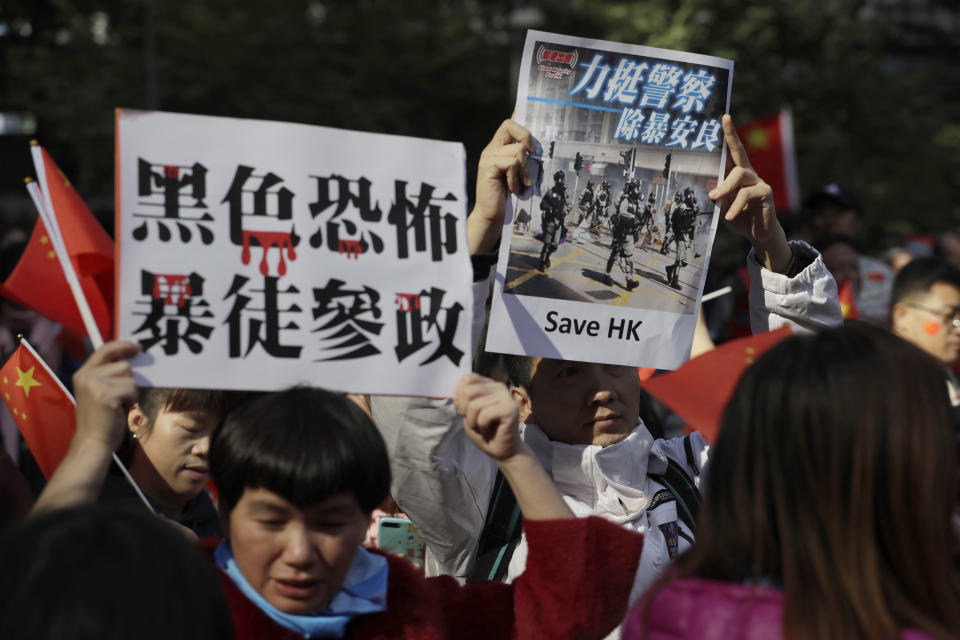 Pro-Beijing supporters hold up signs which reads "Black Terror, Rioters involved in politics" and "Support Police, Get rid of Violence" during a rally in Hong Kong on Saturday, Dec. 7, 2019. Six months of unrest have tipped Hong Kong's already weak economy into recession. (AP Photo/Mark Schiefelbein)
