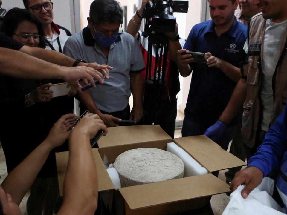 A worker shows a circular-shaped Mayan scoreboard used for a ball game found at Chichen Itza's archaeological site during a news conference, in Merida, Mexico April 11, 2023.