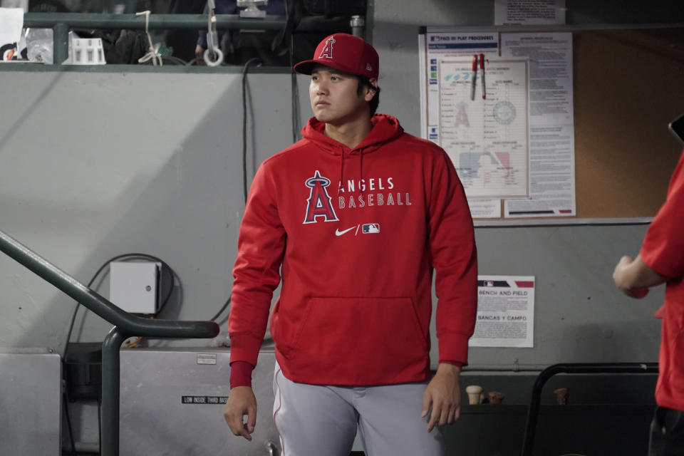 Los Angeles Angels' Shohei Ohtani stands in the dugout before a baseball game against the Seattle Mariners, Sunday, Oct. 3, 2021, in Seattle. (AP Photo/Ted S. Warren)
