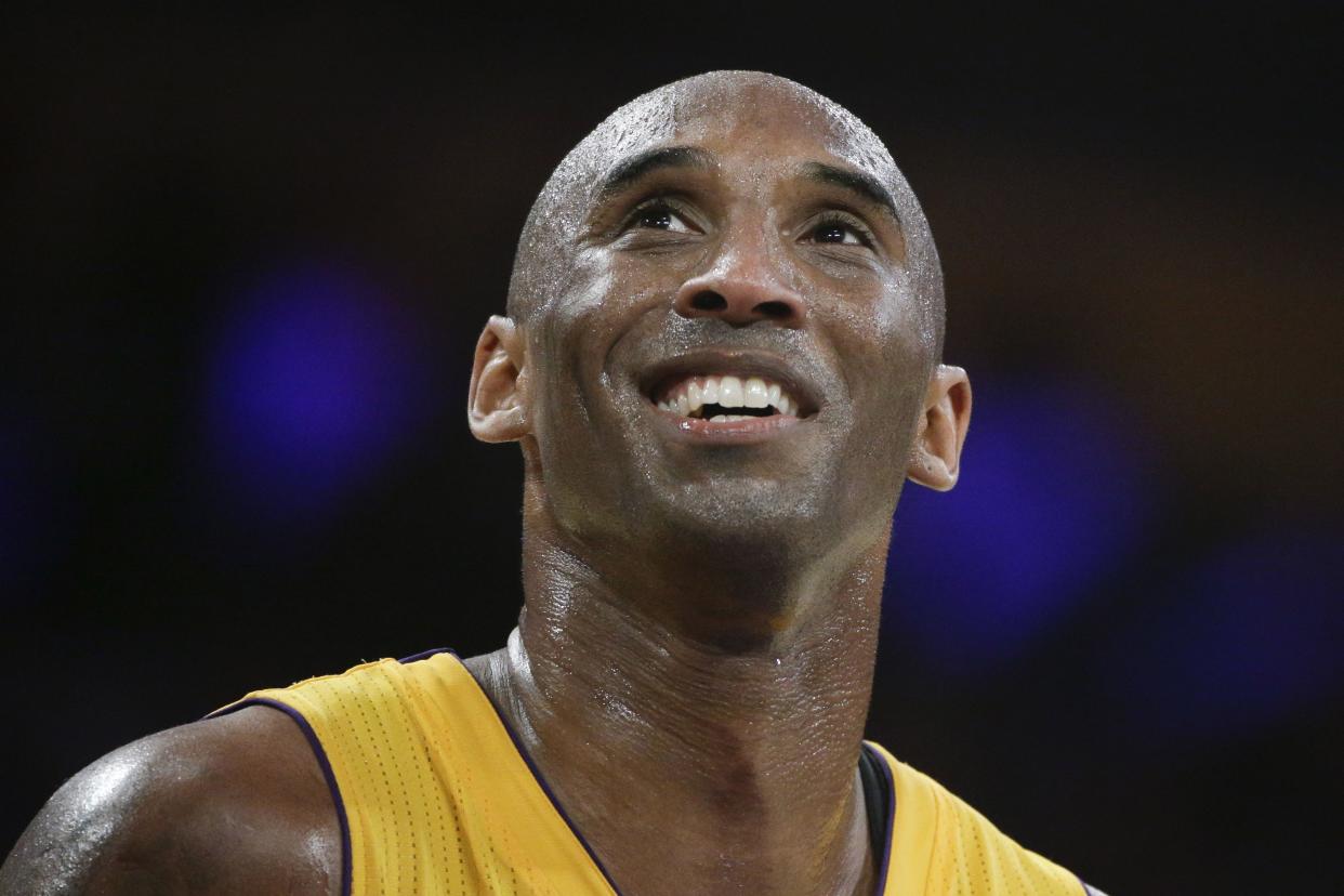 In this April 13, 2016 photo, Los Angeles Lakers forward Kobe Bryant smiles during the first half of his last NBA basketball game, against the Utah Jazz in Los Angeles. 