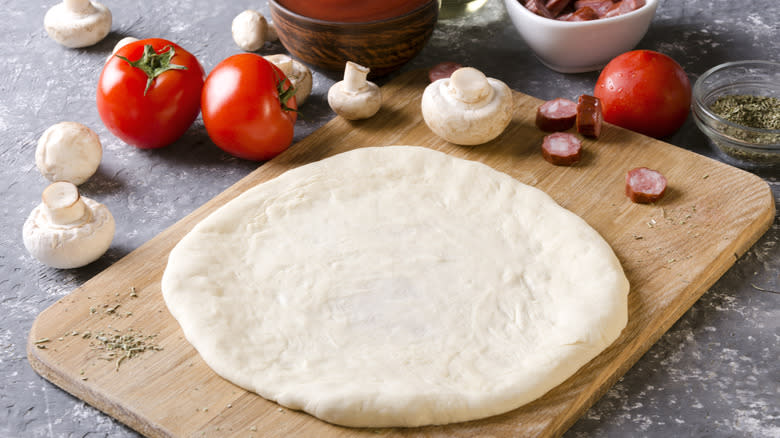 woman holding pizza dough