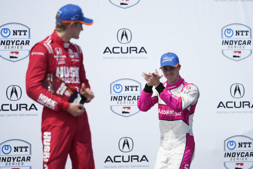 Kyle Kirkwood, right, walks to the podium as third-place finisher Marcus Ericsson watches during the victory ceremony for the IndyCar Grand Prix of Long Beach auto race Sunday, April 16, 2023, in Long Beach, Calif. (AP Photo/Jae C. Hong)