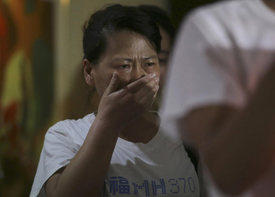 A newly arrived Chinese relative of passengers on board the missing Malaysia Airlines flight MH370 breaks into tears as they spoke to reporters at a hotel in Subang Jaya, Malaysia, Sunday March 30, 2014. Several dozen Chinese relatives of passengers on Flight 370 arrived in Malaysia Sunday to demand more information about what happened to the airliner that has been missing for more than three weeks, saying there has not been enough information on what happened to their loved ones. Her T-shirt reads: "Praying that MH370 returns home safely." (AP Photo/Aaron Favila)