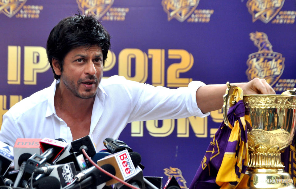 Indian Bollywood actor and Indian Premier League franchise Kolkata Knight Rider’s co-owner Shah Rukh Khan, pictured with the IPL trophy, addresses a press conference in Mumbai on May 30, 2012. Kolkata Knight Riders claimed victory in the annual IPL Twenty20 cricket tournament final on May 27, beating defending champions Chennai Super Kings by five wickets. AFP PHOTO/STR        (Photo credit should read STRDEL/AFP/GettyImages)