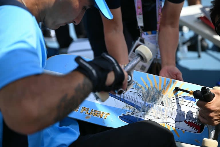 Matías Dell Olio arreglando su patineta durante la competencia de skateboard en la sede de La Concorde, en París 2024