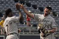 Chicago White Sox's Jose Abreu (79) and Tim Anderson (7) celebrate after the first game of a baseball doubleheader against the Kansas City Royals Tuesday, May 17, 2022, in Kansas City, Mo. The White Sox won 3-0. (AP Photo/Charlie Riedel)