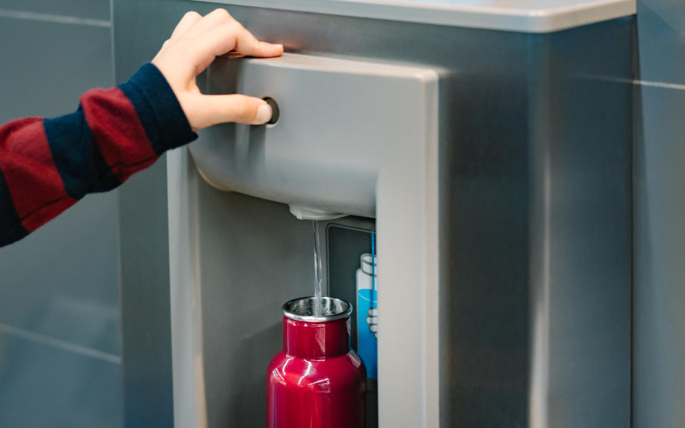 a person filling a water bottle