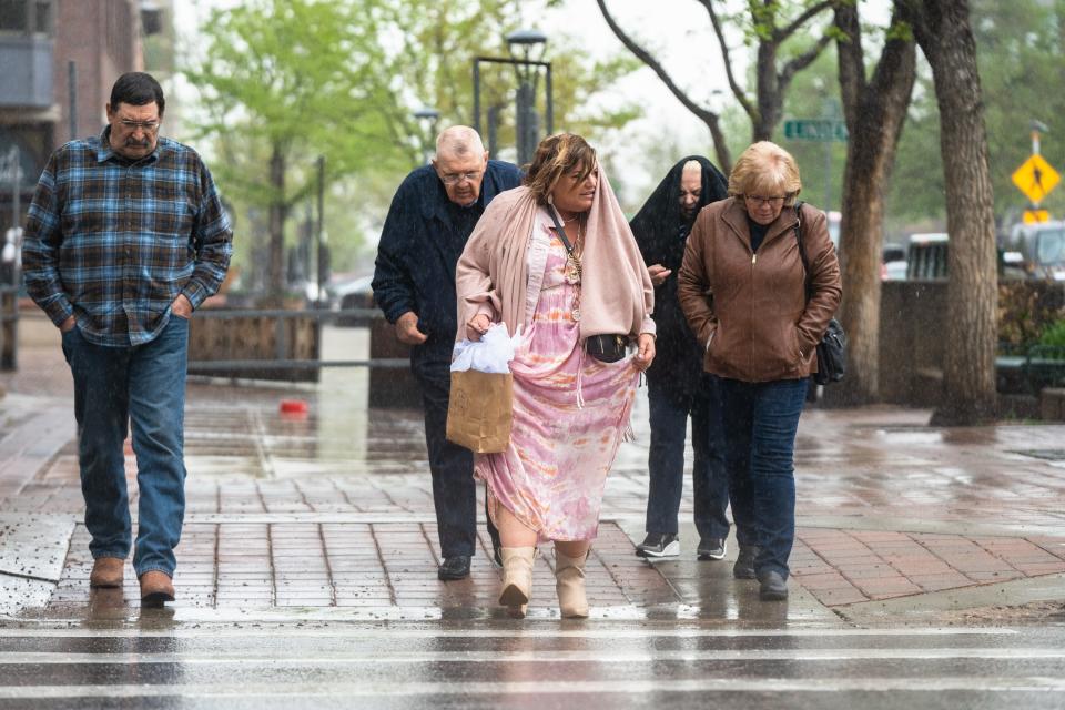 People cross College Avenue at Mountain Avenue during heavy rain in Fort Collins on Thursday.