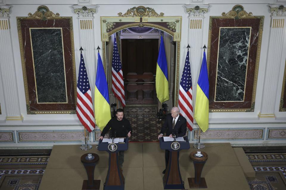 Two men stand at podiums surrounded by U.S. and Ukrainian flags.