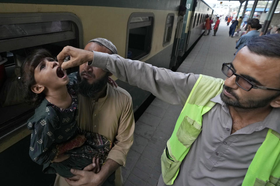 A health worker administers a polio vaccine to a child at a railway station in Karachi, Pakistan, Monday, Sept 18, 2023. Authorities in one province of Pakistan are turning to a controversial new tactic in the decades-long initiative to wipe out polio: prison. Earlier this month, the government in Sindh introduced a law that threatens to imprison parents for up to one month if they fail to get their children immunized against polio or eight other common diseases. (AP Photo/Fareed Khan)