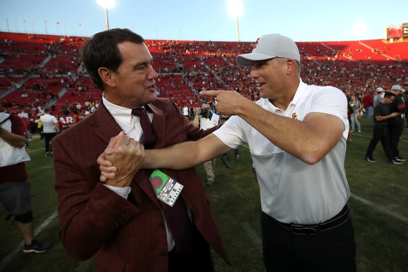 LOS ANGELES, CALIFORNIA - NOVEMBER 23: (L-R) Athletic Director Mike Bohn of the USC Trojans shakes hands with head coach Clay Helton of the USC Trojans after defeating the UCLA Bruins 52-35 in a game at Los Angeles Memorial Coliseum on November 23, 2019 in Los Angeles, California. (Photo by Sean M. Haffey/Getty Images)