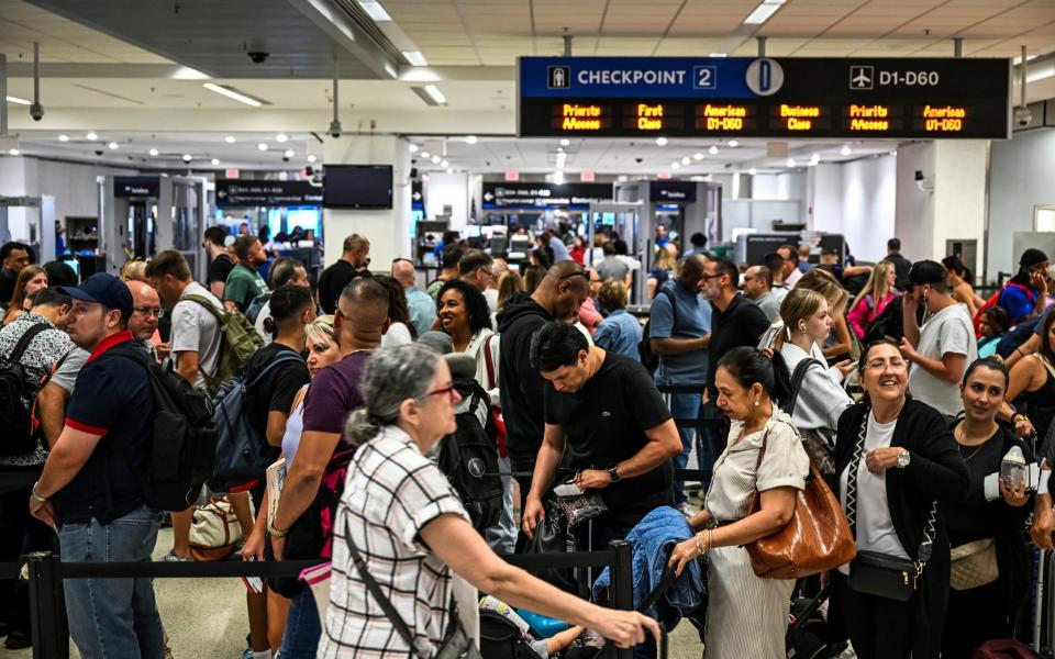 Passengers at Miami International Airport line up as systems were hit by the IT outage