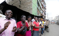 <p>Residents cheer as Kenya Red Cross rescuers evacuate a woman from the rubble of a six-story building that collapsed last Friday after days of heavy rain, in Nairobi, Kenya, May 5, 2016. <i>(Photo: Thomas Mukoya/Reuters)</i></p>