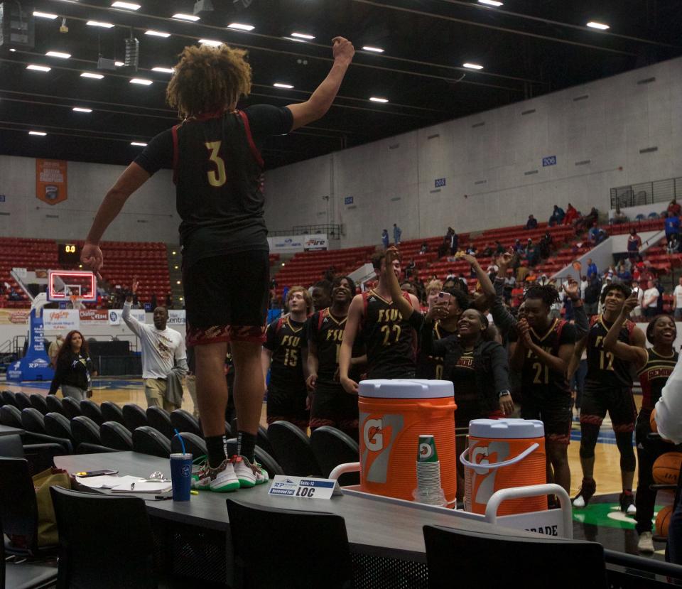 Florida High senior guard Tre Donaldson (3) celebrates with his teammates on top of a table following the Seminoles state championship win over Riviera Prep, 67-66, on March 4, 2022, at R.P. Funding Center.