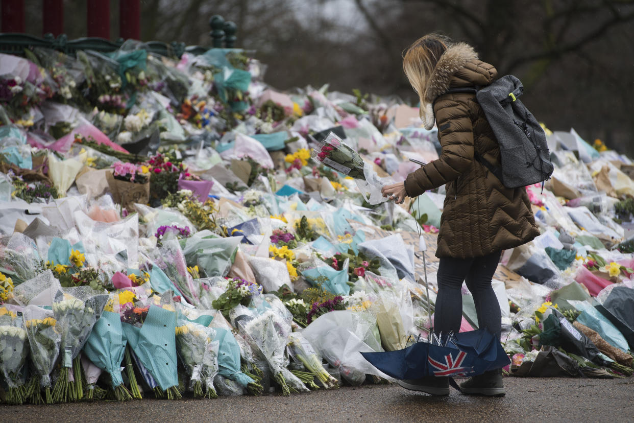 A woman lays flowers at the bandstand in Clapham Common, London, for Sarah Everard. Pc Wayne Couzens, 48, appeared at the Old Bailey in London charged with the kidnap and murder of the 33-year-old. Picture date: Tuesday March 16, 2021.