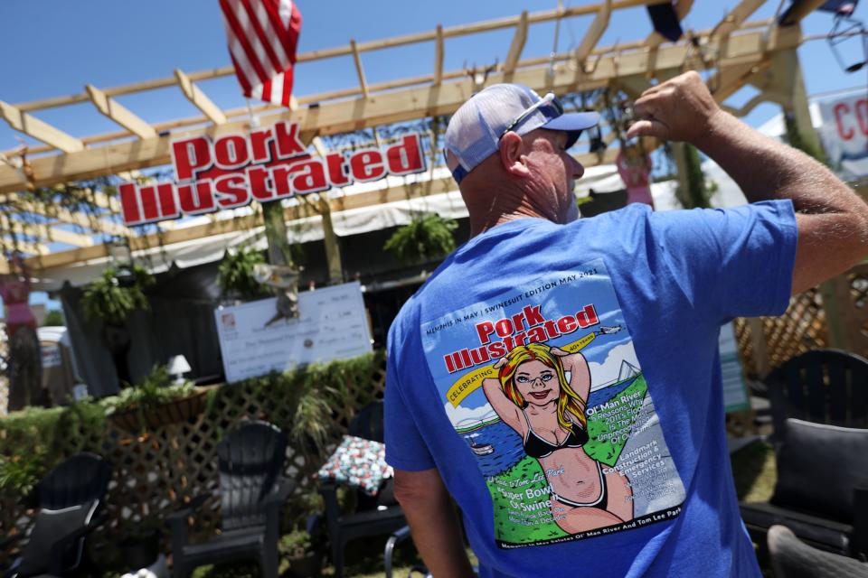 Jet McNeal points out the first-place T-shirt design by Pork Illustrated, which also won first place in the Memphis in May World Championship Barbecue Cooking Contest's Best Booth contest, at Tom Lee Park on May 14, 2021.