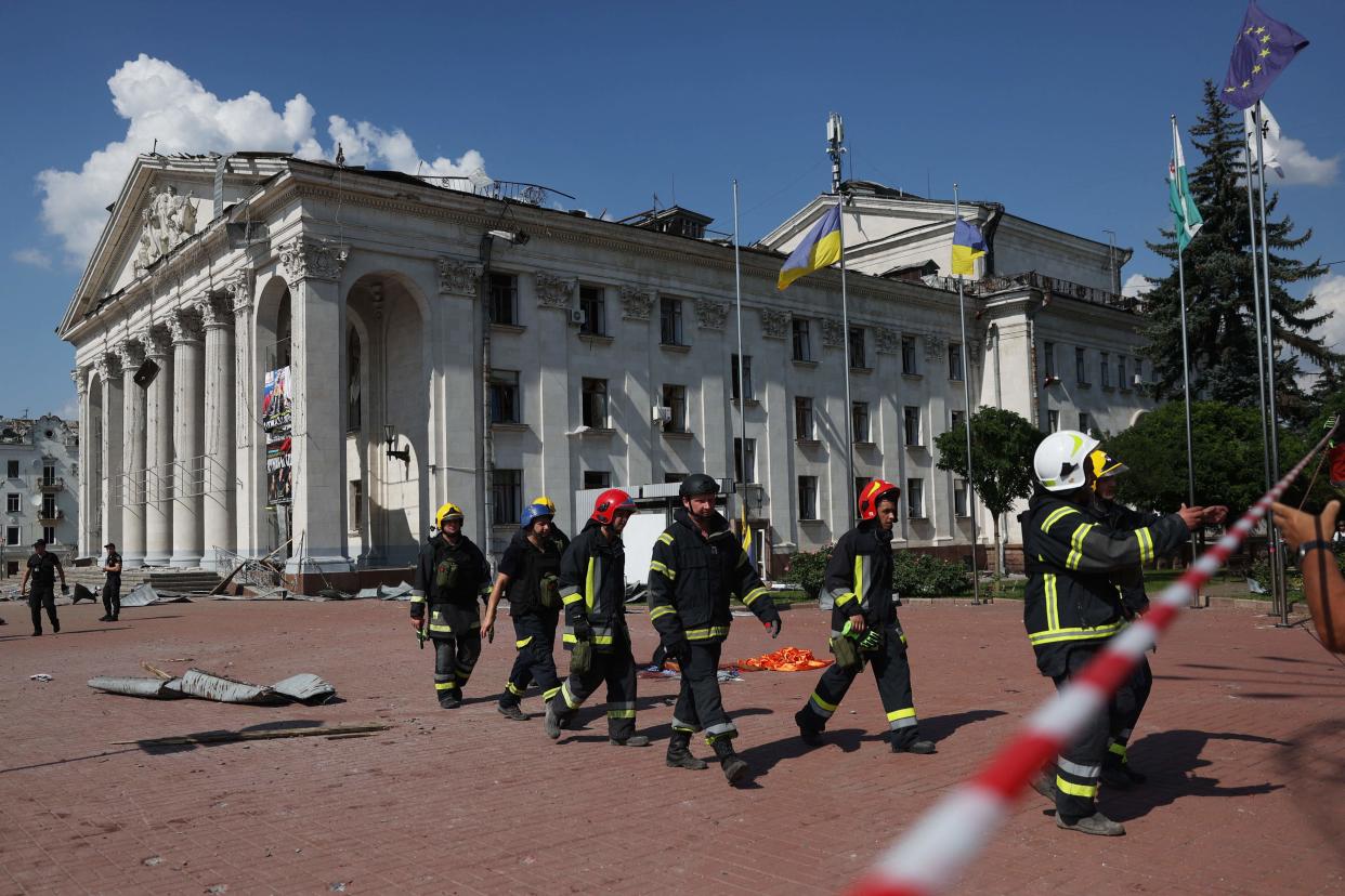 Ukrainian rescuers walk in front of the Taras Shevchenko Chernihiv Regional Academic Music and Drama Theatre (AFP via Getty Images)