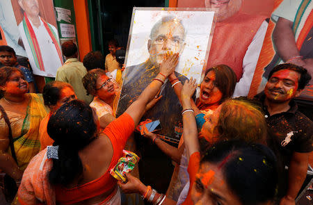 Supporters of the Bharatiya Janata Party (BJP) celebrate after learning of the initial poll results outside the party headquarters in Kolkata, India, March 11, 2017. REUTERS/Rupak De Chowdhuri