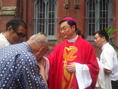 A man kisses Rev. Thaddeus Ma Daqin's hand at a church in Xujiahui, Shanghai in this picture taken July 7, 2012 and provided to Reuters by ucanews.com on October 11, 2013. REUTERS/ucanews.com/Handout via Reuters
