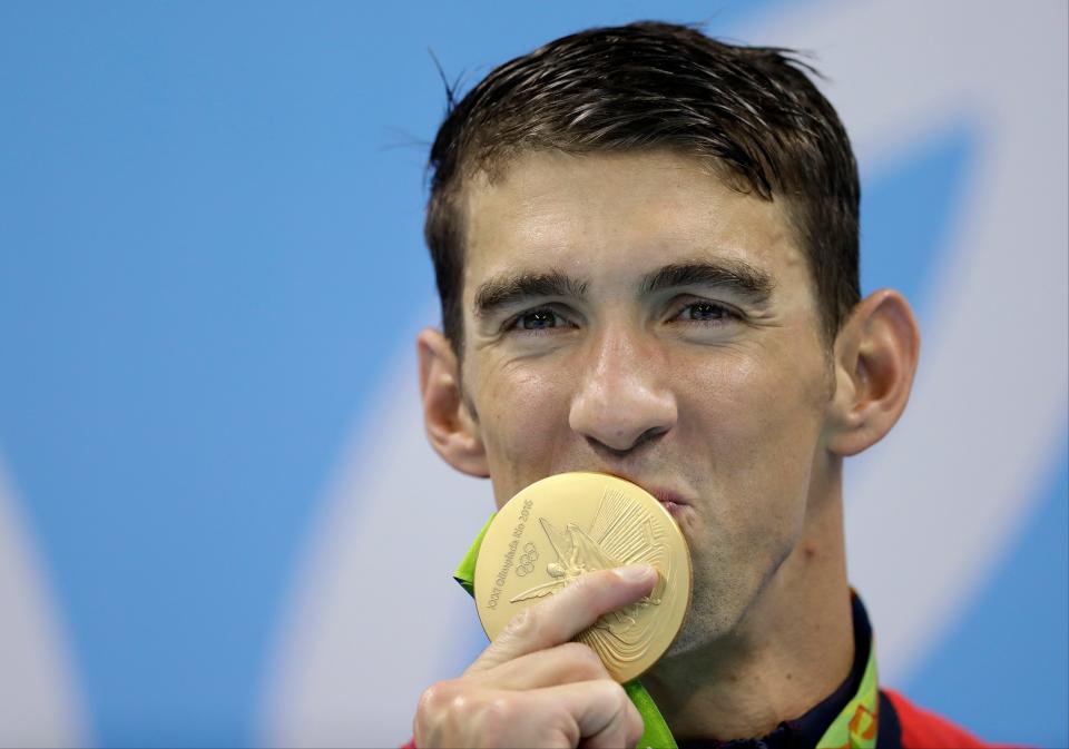 Michael Phelps kisses his gold medal after the men's 400-meter freestyle relay final during the swimming competitions at the 2016 Summer Olympics.
