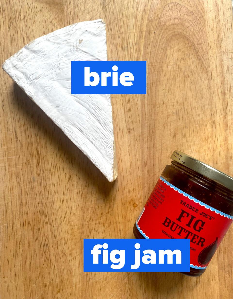 Brie and a jar of fig jam on a cutting board