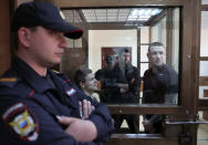 Russian soccer players Pavel Mamayev (R), Alexander Kokorin (L) and their acquaintance Alexander Protasovitsky, who are charged with a brutal assault and held in custody, are seen inside a defendants' cage as they attend a court hearing in Moscow, Russia May 6, 2019. REUTERS/Evgenia Novozhenina