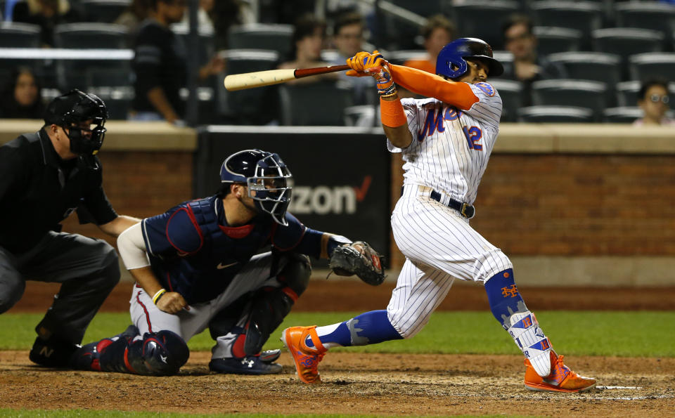 New York Mets shortstop Francisco Lindor (12) follows through on an RBI single against the Atlanta Braves during the eighth inning of a baseball game Wednesday, June 23, 2021, in New York. (AP Photo/Noah K. Murray)