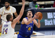 Denver Nuggets center Nikola Jokic, right, reacts as he is fouled while driving to the basket by Los Angeles Lakers center Marc Gasol in the first half of an NBA basketball game Sunday, Feb. 14, 2021, in Denver. (AP Photo/David Zalubowski)