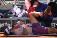A physiotherapist takes care of Stefanos Tsitsipas of Greece as he plays Serbia's Novak Djokovic during their final match of the French Open tennis tournament at the Roland Garros stadium Sunday, June 13, 2021 in Paris. (AP Photo/Michel Euler)