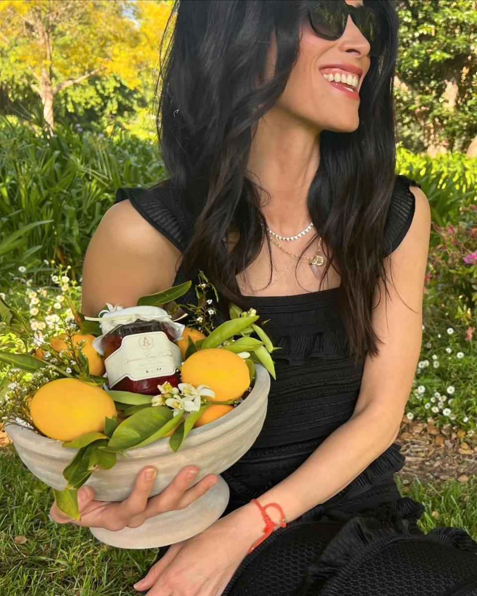 a woman holding a bowl of fruit