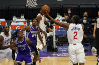 Los Angeles Clippers forward Kawhi Leonard, right, goes for a layup as Sacramento Kings' Richaun Holmes, second from left, and Buddy Hield, third from left, watch during the first quarter of an NBA basketball game in Sacramento, Calif., Friday, Jan. 15, 2021. (AP Photo/Rich Pedroncelli)