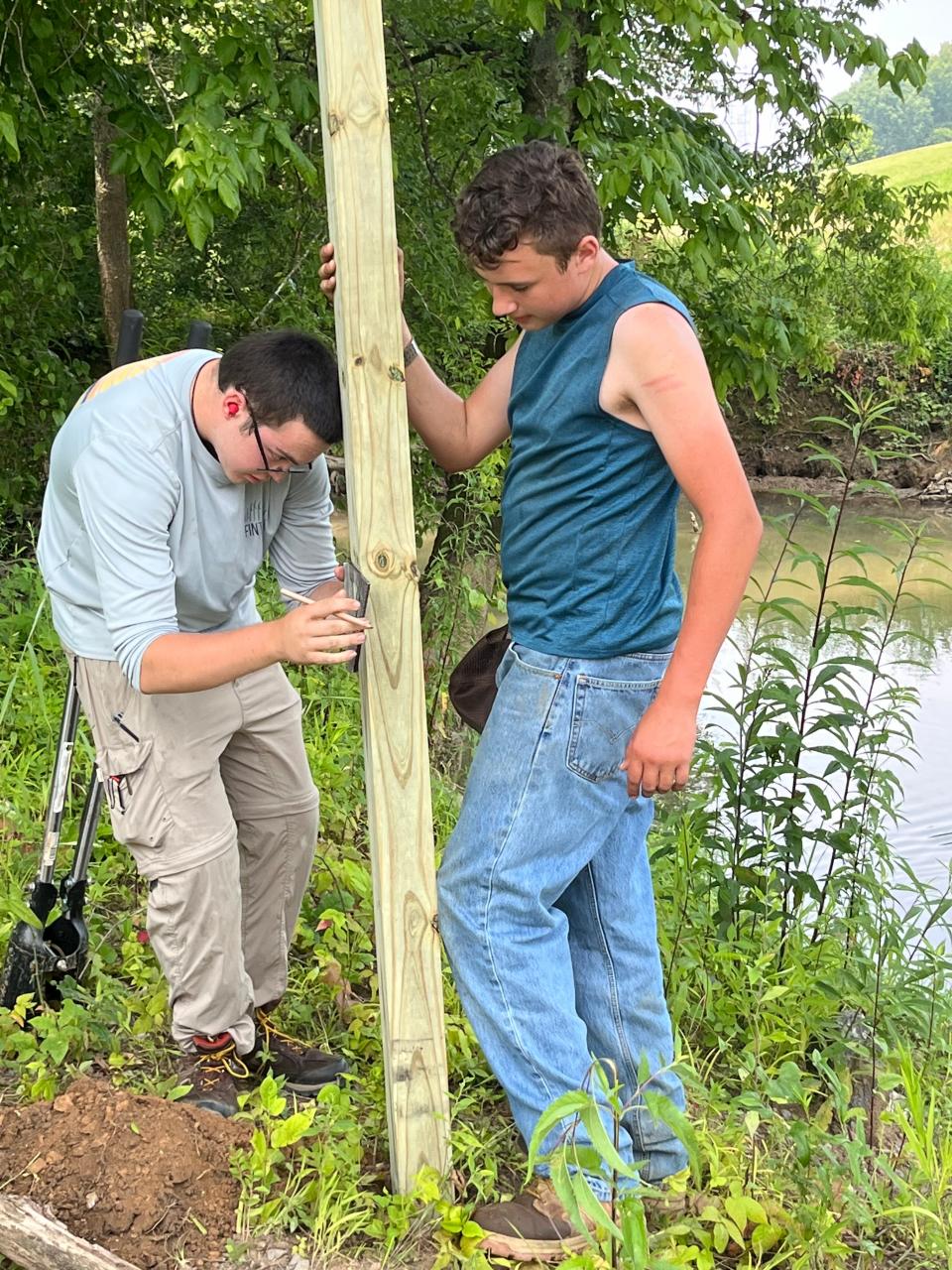 Henry Jordan and Andrew Phillips completed their Eagle Scout projects by mapping Beaver Creek and posting mileage signs along the bank to help first responders with any emergency. Phillips (left) and Jordan work on getting the signposts situated in the ground just right. Aug 2022-Oct 2023