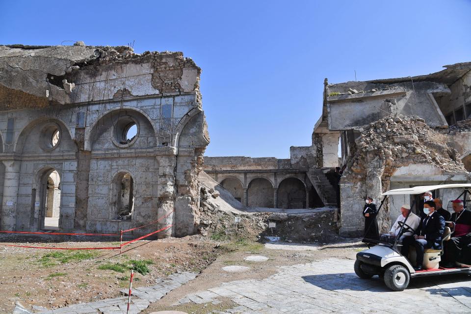 Pope Francis rides in a golf cart at the ruins of the Syriac Catholic Church of the Immaculate ConceptionAFP/Getty