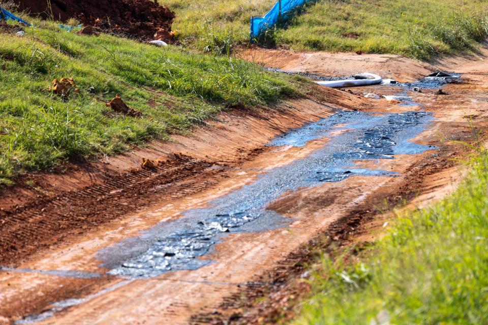 Oil is seen Wednesday in a drainage canal near the site of a spill that happened in northwest Oklahoma City.