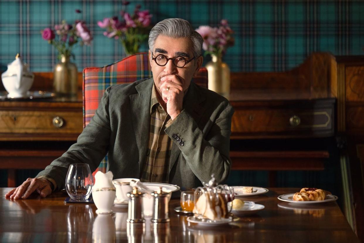 a man sitting at a table with food and drinks