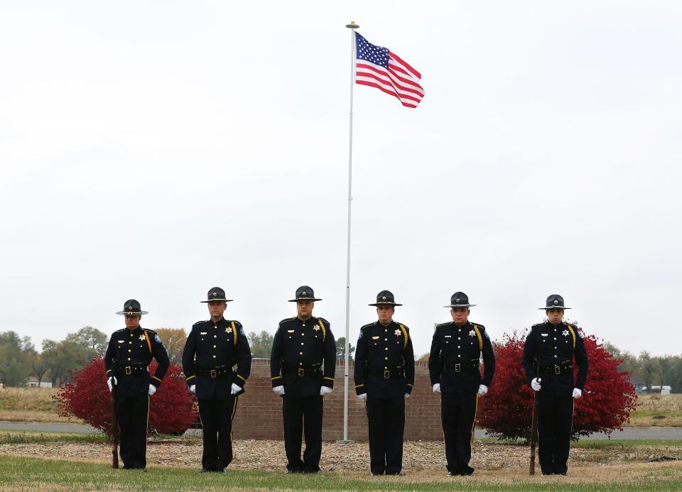 Reno County Sheriff's Department Honor Guard members Shelby Shull, left, David Radke, Matt Franklin, Chris Massingill, Michael Fleming, and Dylen Snedeker stand at attention after posting the American flag on the new flag pole during a dedication ceremony Tuesday afternoon, Nov. 10, 2021, at Hospice House, 1523 E. 20th Ave.