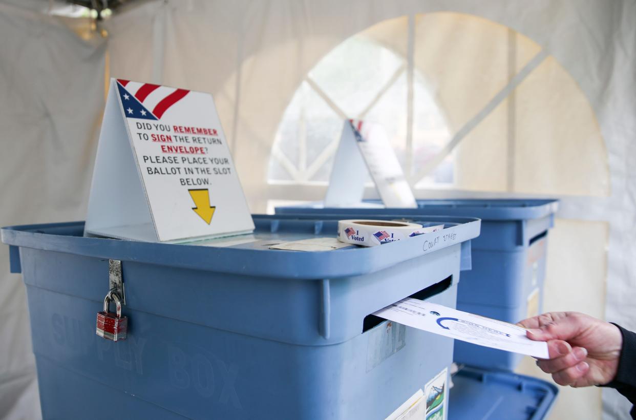 A ballot is placed in a secure drop box at a drive-thru location in Salem in 2021.