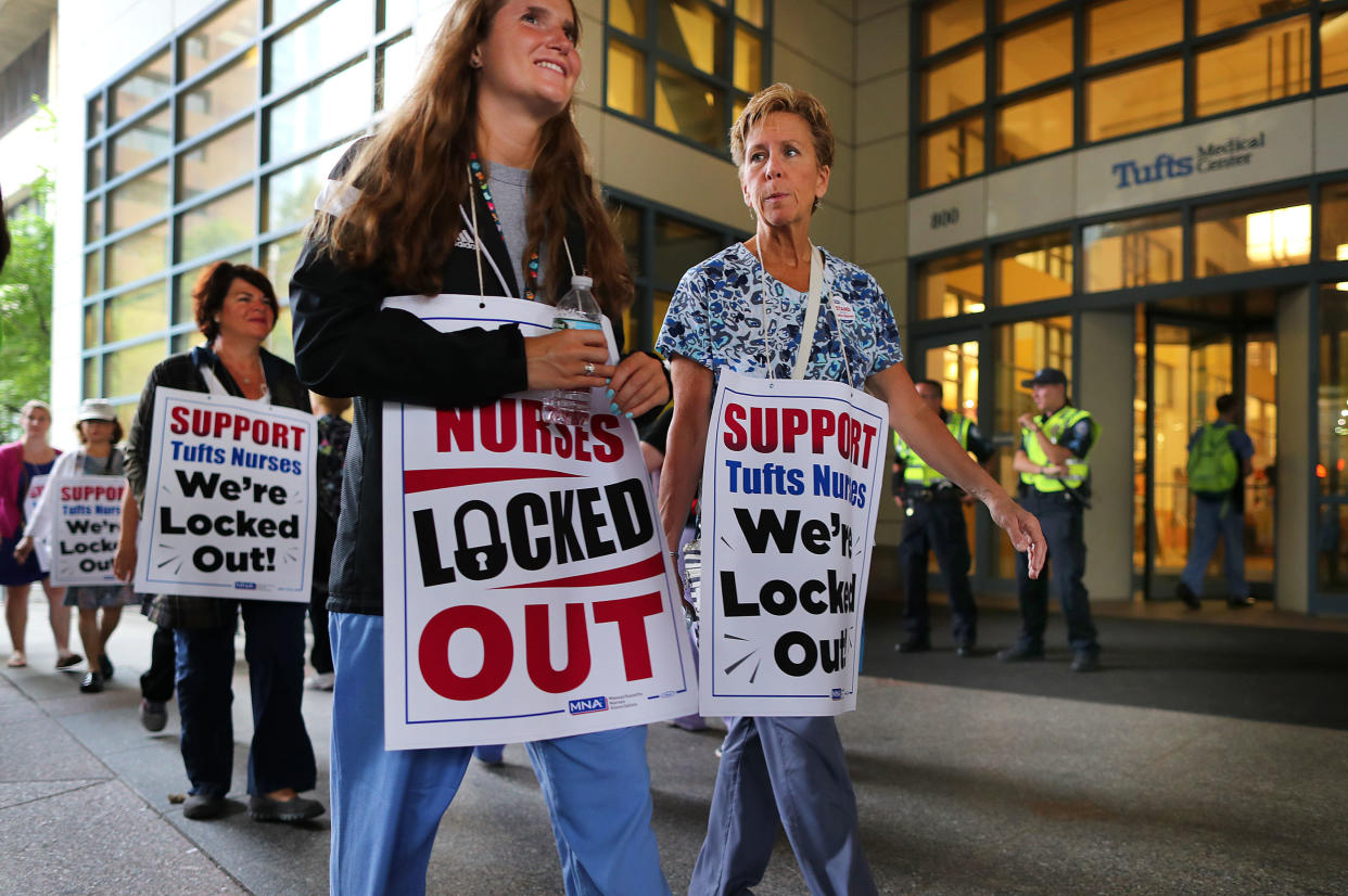 Tufts Medical Center nurses picket in Boston on July 13 after being locked out after a 24-hour strike. One of the sources of stress nurses report is not being included in the decision-making process at health facilities. (Photo: John Tlumacki/The Boston Globe via Getty Images)