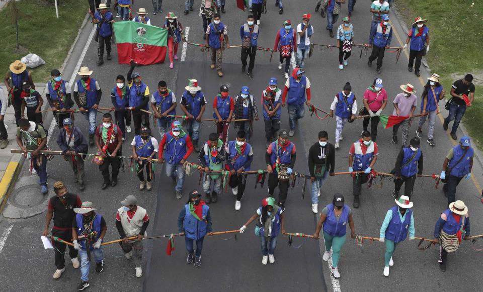 Indigenous people march against the government in Bogota, Colombia, Monday, Oct. 19, 2020. The leaders of the indigenous communities say they are mobilizing to reject massacres, assassinations of social leaders, criminalization of social protest, to defend their territory, democracy and peace, and plan to stay in the capital for a nationwide protest and strike on Oct. 21. (AP Photo/Fernando Vergara)