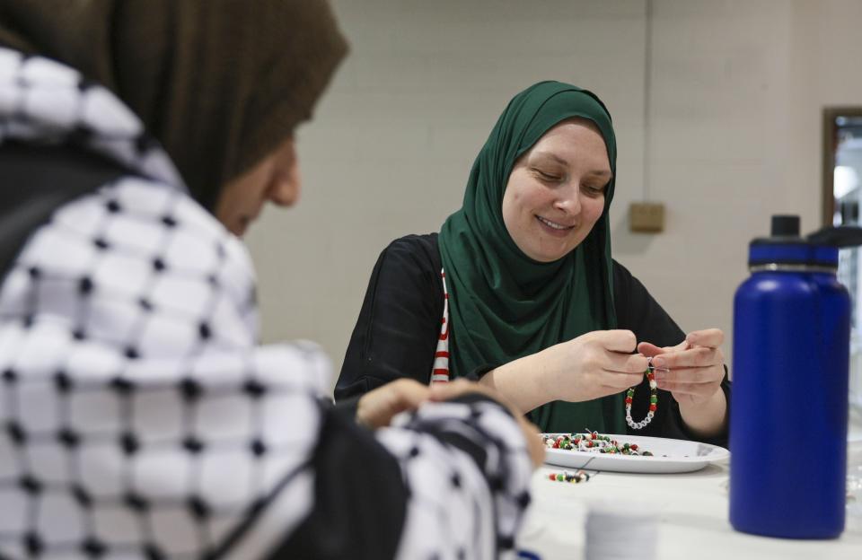 Melissa Saunders ties loose bracelets for her daughter's fundraiser for children affected by the war in Gaza at the Dar Al Jalal Masjid Mosque in Hazelwood, Mo. on Saturday, March 2, 2024. Saunders's daughter is part of former Girl Scout Troop 149 which left the organization after being told to stop their fundraiser by the regional Girl Scout council. (Vanessa Abbitt/St. Louis Post-Dispatch via AP)