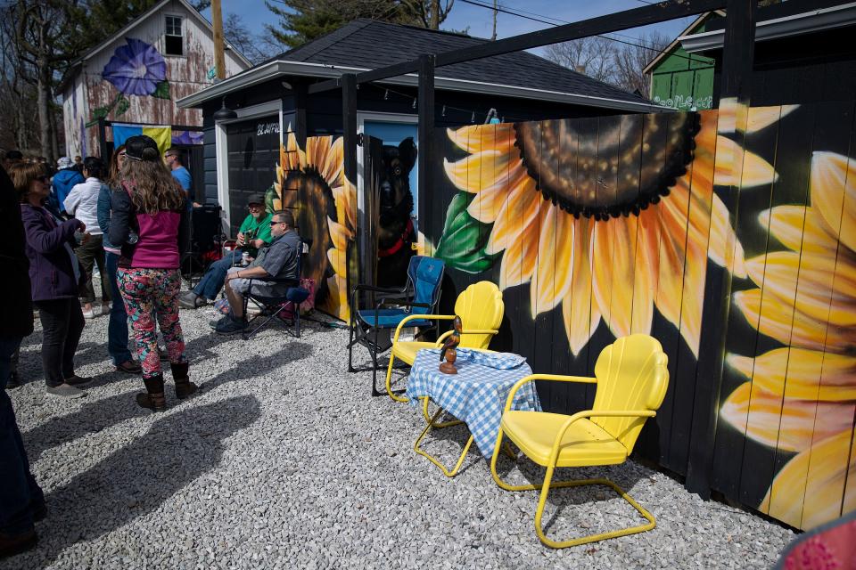 People gather along flower alley for a "Spring Revival" festival on Sunday, April 10, 2022. Flower alley is located in Broad Ripple between Carrollton and Guilford Avenues, just north of 61st Street, where houses and garages are adorned with positive phrases and floral murals by artist Jules Muck, better known as Muckrock. 