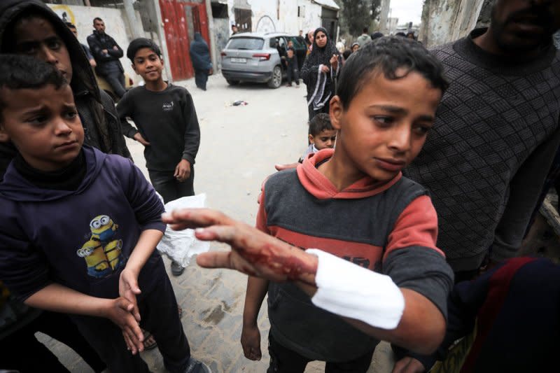 A wounded Palestinian boy stands beside the rubble of his house destroyed by an overnight Israeli bombardment in Rafah in the southern Gaza Strip on Monday. On Thursday, the World Court ordered Israel to allow Palestinians unfettered access to humanitarian aid. Photo by Ismael Mohamad/UPI