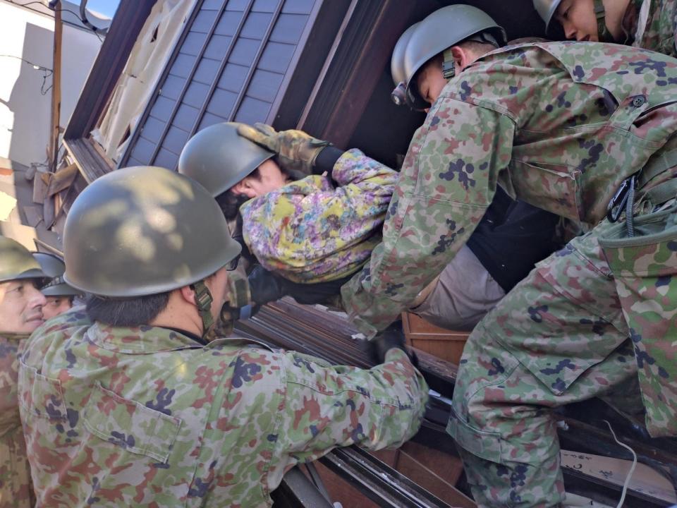 日本發生強震後，自衛隊從輪島市倒塌房屋中救出受困民眾。路透社