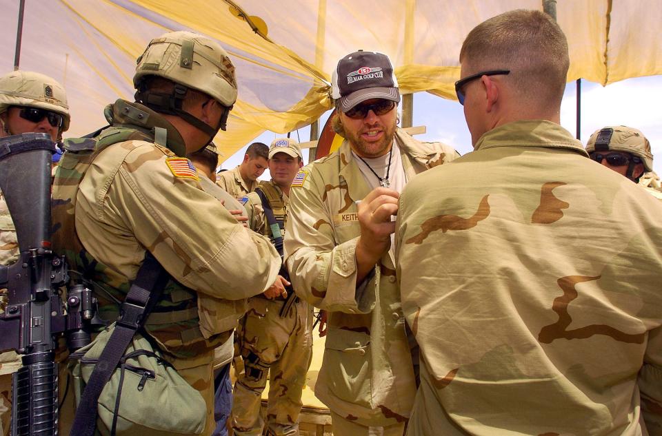 Country music star Toby Keith signs an autograph on the camouflage uniform of a U.S. soldier May 16, 2005, after a United Service Organizations performance at Forward Operating Base Danger, near Tikrit, Iraq.